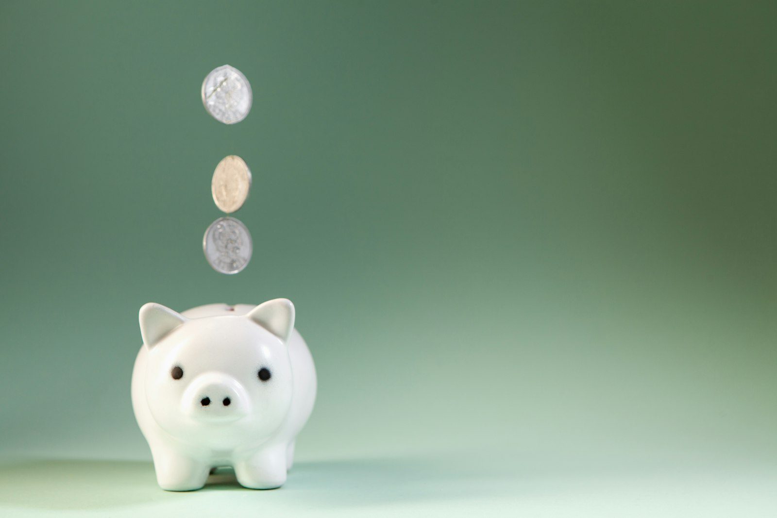 Копилка на столе рядом с монетами